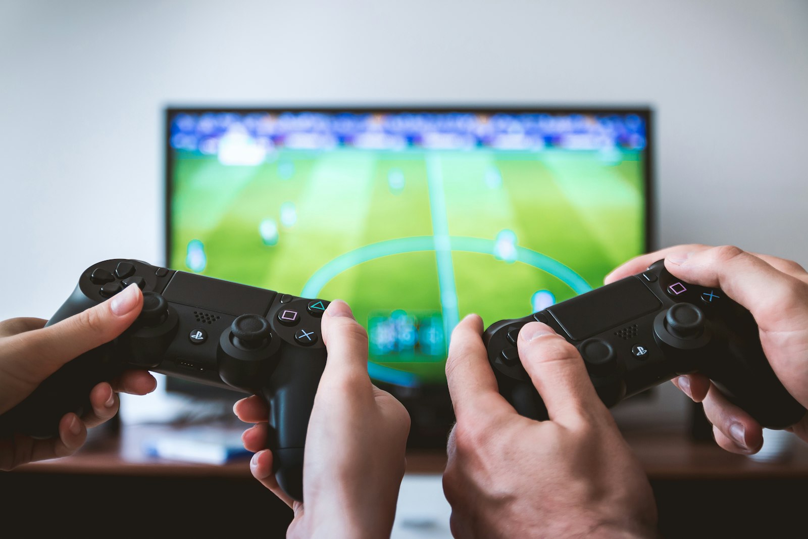 Players holding game controllers in front of a screen